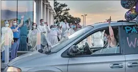  ?? Gina Ferazzi Los Angeles Times ?? DOCTORS AND nurses wave as a drive-by rally honors heroes of the pandemic at the ER entrance to Riverside University Health System in Moreno Valley.