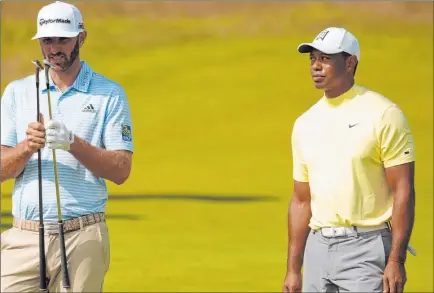  ?? Jon Super The Associated Press ?? Tiger Woods and Dustin Johnson, as the latter compares clubs during a British Open practice round Monday at Royal Portrush in Portrush, County Antrim in Northern Ireland. The 148th Open begins on Thursday (Wednesday night Pacific Daylight Time).