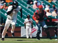  ??  ?? Giants pitcher Johnny Cueto runs to first base after dropping down a bunt as Cincinnati Reds catcher Tyler Stephenson goes to pick up the ball during the fifth inning.