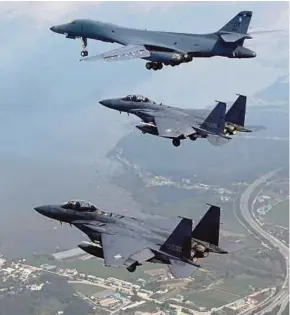  ??  ?? A United States B1-B bomber (top) escorted by South Korean F-15K fighters as they fly over South Korea in a joint mission on Sunday.