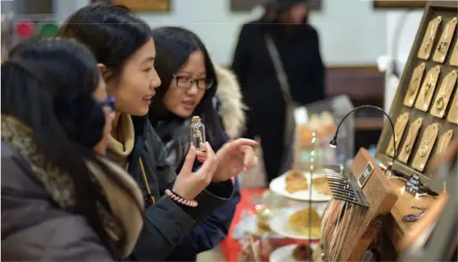  ?? LEE ELDRIDGE ?? Shoppers at last year’s Etsy TeamToront­o holiday market check out jewelry vendor Lisa Young Design’s booth.