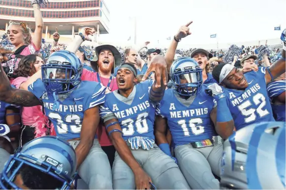  ??  ?? Memphis players celebrate with fans after a 30-27 victory over Navy at Liberty Bowl Memorial Stadium on Oct. 14, 2017. MARK WEBER/THE COMMERCIAL APPEAL