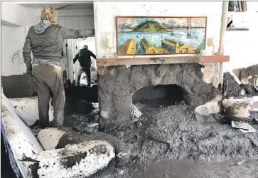  ?? Mike Eliason Santa Barbara County Fire Department ?? TERESA DRENICK stands in her sister’s Montecito home off Glen Oaks Lane as Sean Bornwell, rear, looks for items to salvage. Drenick’s sister has been missing since a mudslide hit the house early Tuesday morning.