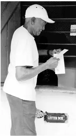  ?? IAN ALLEN/STAFF PHOTOGRAPH­ER ?? Gladstone Terrill collecting his mail last Wednesday at the Devon Pen Postal Agency in St Mary, one of the few postal agencies which remain open in the parish.