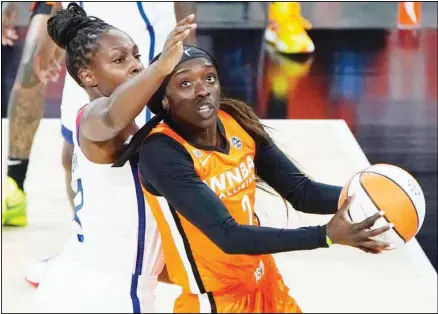  ??  ?? Team WNBA’s Kahleah Copper shoots around United States’ Chelsea Gray during the first half of a WNBA All-Star basketball game, on July 14, in Las Vegas. (Bottom right) Allie Quigley of the Chicago Sky holds up a trophy after winning the 3-point contest during halftime of a WNBA All-Star basketball game. (AP)