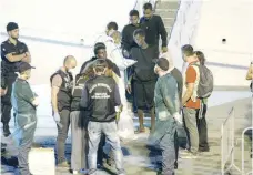  ?? — Reuters ?? Unaccompan­ied minor migrants disembark from the Italian coast guard vessel “Diciotti” at the port of Catania, Italy.