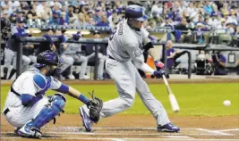  ?? Morry Gash ?? The Associated Press Manny Machado hits a single in his first Dodgers at-bat in front of Brewers catcher Manny Pina during the first inning of Los Angeles’ 6-4 victory Friday at Miller Park.