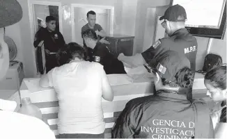  ??  ?? Agentes de la Policía Federal durante revisión de documento en local “pafo” en Parral.