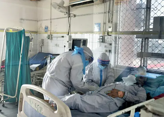  ??  ?? COURSE OF TREATMENT Doctors attend to a Covid patient at the LNJP Hospital in Delhi