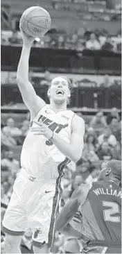  ?? CHUCK BURTON/AP ?? TheHeat’s Kelly Olynyk shoots against Hornets’ Marvin Williams Wednesday.Olynyk had 22 points and 11 rebounds.