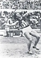  ??  ?? Dana Zatopkova, above, on her way to javelin gold at the 1952 Olympics. Above right, with her husband, and below, the couple’s trackside kiss after Zatopek’s victory in the marathon at the same Games