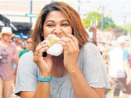  ?? WISCONSIN STATE FAIR ?? A woman enjoys a freshly baked cream puff at the Wisconsin State Fair. The long-popular treats cost $4.50 each or $22 for a pack of six.