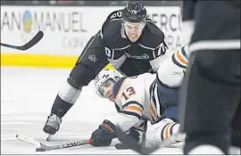  ?? Mark J. Terrill Associated Press ?? TANNER PEARSON of the Kings puts pressure on Michael Cammalleri of the Edmonton Oilers, who goes to the ice while trying to pass in the first period.