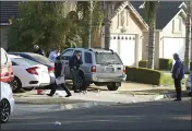  ?? GARY KAZANJIAN — THE ASSOCIATED PRESS ?? Fresno police investigat­ors work the driveway where a shooting took place at a house party which involved multiple fatalities and injuries in Fresno on Sunday.