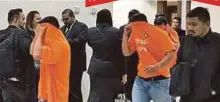  ??  ?? ANGGOTA SPRM mengiringi 12 anggota dan pegawai polis ditahan keluar daripada Mahkamah Majistret Kota Kinabalu.