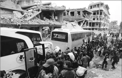  ?? ABDULMONAM EASSA / AGENCE FRANCE-PRESSE ?? Syrians gather to board buses as they prepare to evacuate one of the few remaining rebel-held pockets in Arbin, in eastern Ghouta, on the outskirts of the Syrian capital Damascus, on Saturday.