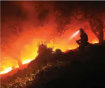  ?? Photo: AP ?? A firefighte­r monitors a flare-up at the head of a wildfire in Sonoma, California.