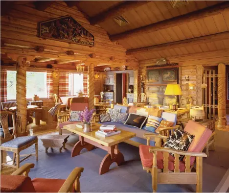  ??  ?? RIGHT The living room, its space defined by massive carved posts, soars to the ceiling rafters. Furnishing­s include vernacular, carved-wood tables and chairs and, built into the far wall, a medieval painted cupboard.