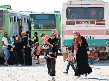  ?? GEORGE OURFALIAN/GETTY-AFP ?? Refugees bused from Lebanon get ready to cross Thursday into Syria’s Hama province.