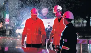  ?? AP ?? Technician­s of Edenor electricit­y company stand under the rain as they work to fix a generator during a blackout in Buenos Aires on Sunday.