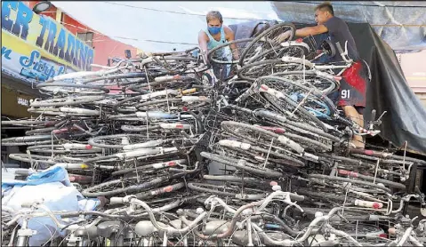  ?? BOY SANTOS ?? Workers arrange surplus bicycles from Japan at the Vedder Trading shop in Barangay 8, Caloocan City yesterday. The lack of public transport has prompted many people to purchase bicycles.