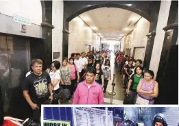  ??  ?? TENSION AT MAKATI CITY HALL — Employees and visitors line up at the service
elevators of Makati City Hall
yesterday as anti-riot police stand opposite supporters
of Mayor Junjun Binay,
a day after the Court of Appeals issued
a temporary...