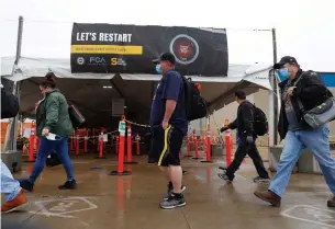  ?? PAUL SANCYA THE ASSOCIATED PRESS ?? Autoworker­s leave the Fiat Chrysler pickup truck assembly plant in Warren, Mich., on Monday after their first work shift back after several weeks of inactivity due to the coronaviru­s pandemic.