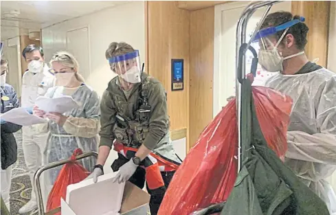  ??  ?? TAKING PRECAUTION­S: Medical personnel Guardian Angels with the 129th Rescue Wing, alongside individual­s from the CDC don full personal protective equipment as they prepare to test travellers on the ‘Grand Princess’ cruise ship currently off the coast of California.