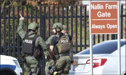  ?? ASSOCIATED PRESS ?? Members of the Frederick Police Department Special Response Team prepare to enter Fort Detrick at the Nallin Farm Gate in a convoy of vans and sedans following a shooting in Riverside Tech Park, near the Royal Farms on Monocacy Boulevard, Tuesday in northeast Frederick, Md.