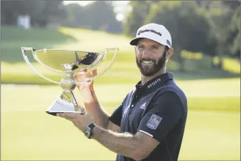  ?? ASSOCIATED PRESS ?? DUSTIN JOHNSON CELEBRATES WITH THE FEDEX CUP TROPHY after winning the Tour Championsh­ip golf tournament on Monday at Lake Golf Club in Atlanta.