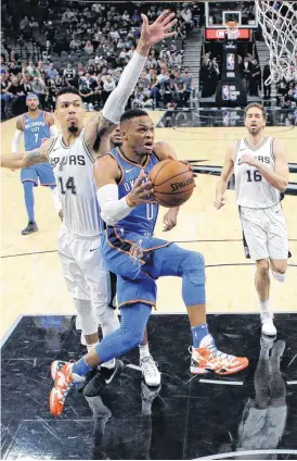  ??  ?? Oklahoma City Thunder guard Russell Westbrook drives to the basket past San Antonio Spurs guard Danny Green.