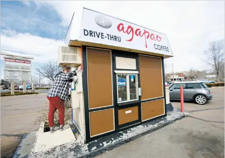  ?? PHOTOS BY LUIS SÁNCHEZ SATURNO/THE NEW MEXICAN ?? Jessica Black, 28, works Monday on painting the Agapao Coffee and Tea kiosk on St. Michael’s Drive, which the owner hopes to open Friday.