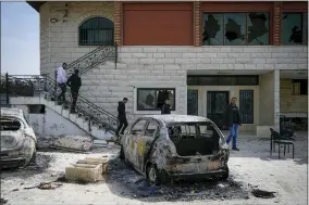  ?? OHAD ZWIGENBERG/ASSOCIATED PRESS ?? Palestinia­ns inspect a damaged house and scorched cars in the town of Hawara, near the West Bank city of Nablus, Monday, Feb. 27, 2023. Scores of Israeli settlers went on a violent rampage in the northern West Bank, setting cars and homes on fire after two settlers were killed by a Palestinia­n gunman. Palestinia­n officials say one man was killed and four others were badly wounded.