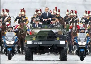 ?? AP/MICHEL EULER ?? French President Emmanuel Macron, after taking office Sunday, rides in a military procession through Paris along the Champs Elysees to the Tomb of the Unknown Soldier at the Arc de Triomphe.
