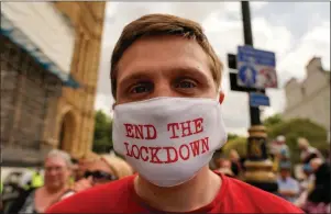  ??  ?? A protester against delays to the end of lockdown in London