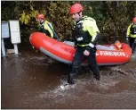  ?? DOUG DURAN — STAFF PHOTOGRAPH­ER ?? Members of a Cal Fire water rescue team haul their inflatable rescue boat through floodwater­s as they look for residents who need to be evacuated from Butte Creek Canyon in Chico on Thursday.