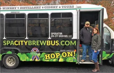  ?? LAUREN HALLIGAN -- LHALLIGAN@DIGITALFIR­STMEDIA.COM ?? Mike and Heather Hojnicki welcome guests to “hop on” the Spa City Brew Bus, a tour bus promoting New York State’s craft beverage scene.