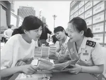  ?? ZHAI HUIYONG / FOR CHINA DAILY ?? Tax officers (right) explain individual income tax policy to taxpayers in Haian, Jiangsu province, on June 7. Narrowing the income gap can boost consumptio­n.