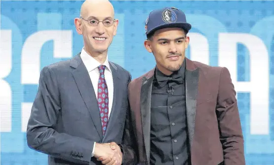  ?? [AP PHOTO] ?? Oklahoma’s Trae Young, right, shakes hands with NBA Commission­er Adam Silver after he was picked fifth overall by Dallas in Thursday’s draft. He later was traded to Atlanta.