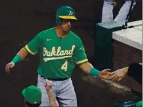  ?? JACK DEMPSEY — THE ASSOCIATED PRESS, FILE ?? The A’s Jake Lamb is congratula­ted after scoring against the Rockies during the second inning on Tuesday in Denver.