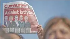  ??  ?? ISTANBUL: A protester holds Cumhuriyet daily newspaper during a demonstrat­ion before the controvers­ial trial of staff from Turkey’s main opposition daily in the Silivri district in Istanbul. — AFP