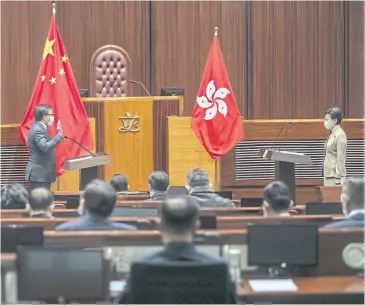  ?? BLOOMBERG ?? Chief executive Carrie Lam, right, stands during an oath-taking ceremony in Hong Kong yesterday.