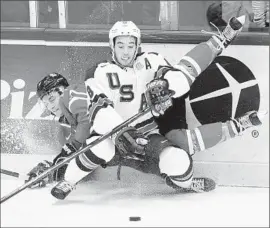  ?? Sean Kilpatrick Associated Press ?? TEAM USA defenseman Louie Belpedio checks Canada’s Brendan Perlini during the Americans’ 4-2 win Saturday at the world junior championsh­ips in Finland.