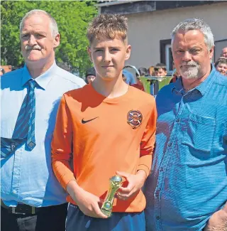  ??  ?? Jordan Timmons is presented with the Man-of-the-Match award by DDYFA officials Jim Falconer and Sandy Edmonds after Fairmuir U/16’s Queen’s Jubilee Cup win.