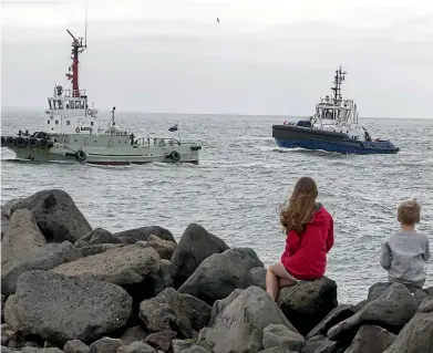  ?? JOHN BISSET/STUFF ?? Timaru’s new tug Hinewai, at rear, arrives at the port yesterday, watched by Brooke, 13, and Mytchall, 7, Crump.