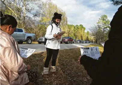  ?? Yi-Chin Lee / Staff photograph­er ?? Volunteer Adilene Ramirez registers women for a weekly food distributi­on and hands out flyers about the COVID vaccine.