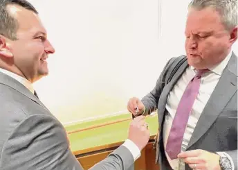  ?? Courtesy of Nick DeSimone ?? Jimmy Byrn, left, hands Sergiy Kyslytsya, Ukrainian ambassador to the United Nations, a tie clasp with a replica of an Abrams tank at the Yale School of Management.