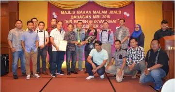  ??  ?? Penguang (standing, fifth right) presents the championsh­ip trophy to a representa­tive of Ruwas Merah during the dinner in Miri.