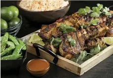  ?? Chicago Tribune/TNS ?? ■ Pork country ribs marinate in a mixture of onion, garlic, ginger and lemongrass purees, fish sauce, chile, salt, pepper, coriander, cumin and turmeric before being grilled and then served with fresh lime and bottled peanut sauce.