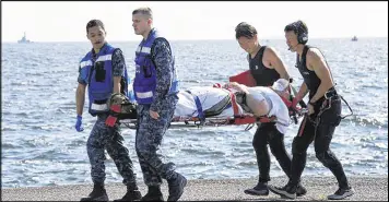  ?? JAPAN DEFENSE MINISTRY / ASSOCIATED PRESS ?? An injured sailor from the USS Fitzgerald is carried by U.S. military personnel (left) and Japanese Maritime Self-Defense Force members upon arriving at the U.S. Navy base in Yokosuka, Japan, on Saturday.